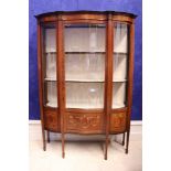 A FINE EARLY 20TH CENTURY SERPENTINE SHAPED GLAZED DISPLAY CABINET, with curved glazed central door,