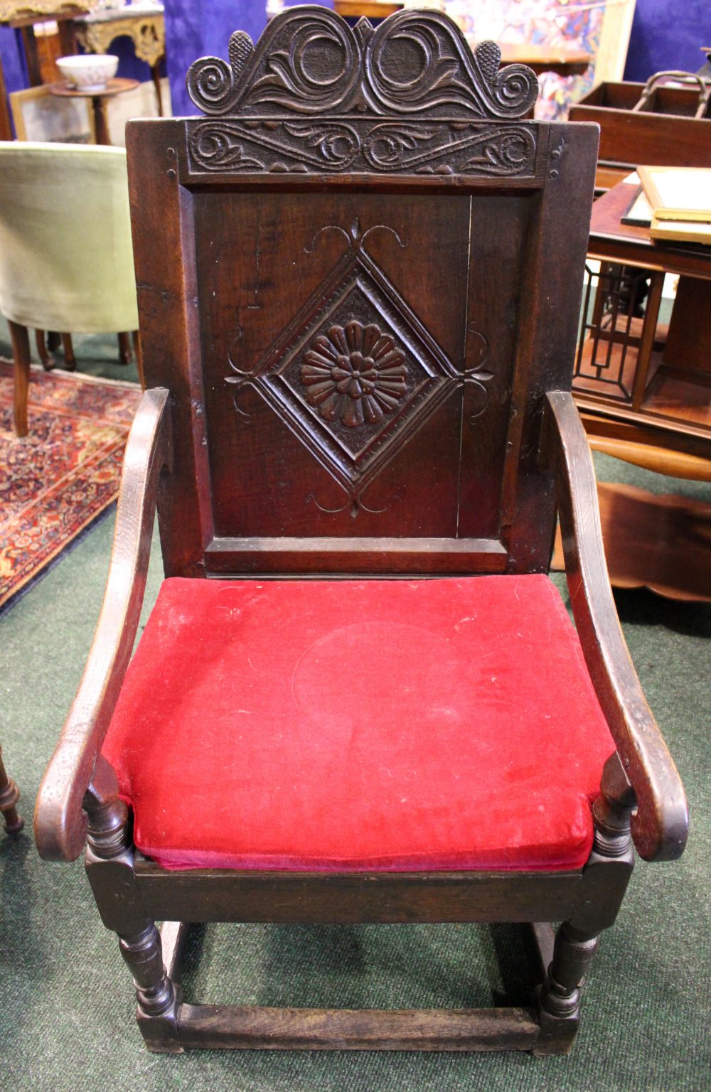 AN OAK “WAINSCOT” ARMCHAIR, with square panel back, having carved top rail, and lozenge shaped