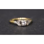 AN 18CT & PLAT EDWARDIAN DIAMOND RING, with foliage mount, flanking central diamond