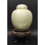 A DARK GREEN CELADRON GINGER JAR WITH LID, having a brown rim, no mark beneath, sitting on a