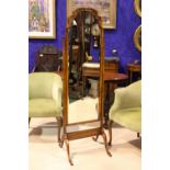 A MAHOGANY cross banded CHEVAL MIRROR, with shaped frame, bevelled mirror glass, raised on two pairs