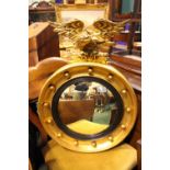 A GILT WOOD REGENCY ROUND CONVEX MIRROR, with eagle mount, ebonised reeded slip