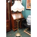 AN ADJUSTABLE BRASS STANDARD LAMP, with circular base, and tripod lion paw feet, 62" high approx