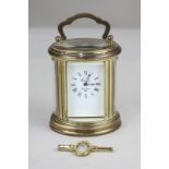 An brass and bevelled cased oval boudoir carriage clock by L'Epee, the face with Roman numerals