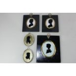 A pair of gold leaf mounted silhouette profile portraits of ladies, on glass, in oval glazed