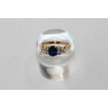 A sapphire and diamond ring, the oval cut stone with a trefoil of diamonds to each side, in 18ct