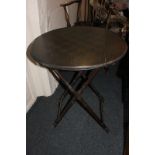 A Victorian circular folding table with stained chessboard top, on faux bamboo supports, 60cm