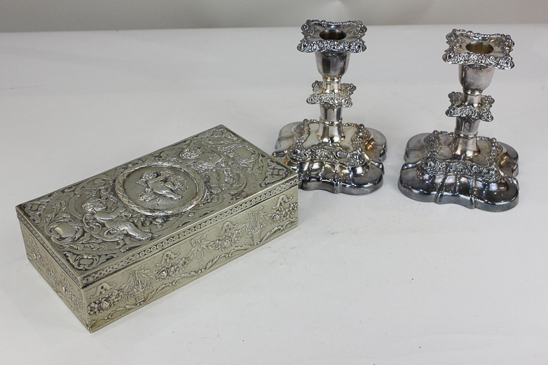 A pair of silver plated dwarf candlesticks with scroll decorated borders and drip trays, and a