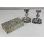 A pair of silver plated dwarf candlesticks with scroll decorated borders and drip trays, and a