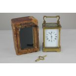 A gilt brass and bevelled glass cased carriage clock, the white rectangular dial with Roman