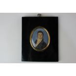 An 18th century oval miniature portrait of a gentleman, in a black coat, on ivory, 7cm by 5.5cm