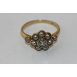 A diamond and pearl cluster ring with a rubover set old cut diamond within a border of seven split