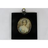 A 19th century oval miniature portrait of a lady, in a blue gown with flowers in her hair, on ivory,
