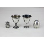 A pair of George V silver egg cups, Sheffield 1910, and two peppers