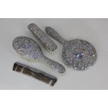 A modern silver backed four-piece dressing table set of two brushes, hand mirror and comb, decorated