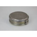 A George V silver circular box with hinged cover and scroll slip fastener, maker Robert Frederick