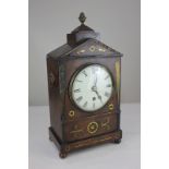 A Regency mantel clock, five inch dial with Roman numerals, with brass inlaid mahogany arched case