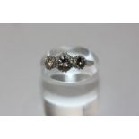 A diamond three stone ring double claw set with graduated round brilliant cut stones in platinum,