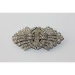 An Art Deco diamond double clip brooch of pierced stylised ribbon bow form set throughout with