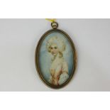 An early 19th century oval miniature portrait of a young lady, in a pink and white dress, on