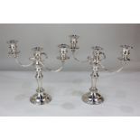 A pair of silver plated three-light candelabra with scroll branches, urn shape sconces with drip