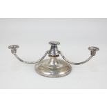 A modern silver small three-light candlestick on loaded circular base, marks rubbed, probably