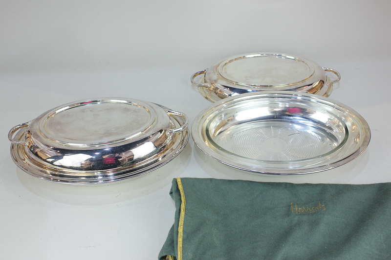 A pair of silver plated oval entree dishes with replacement clear glass liners, in Harrods green