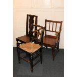 A country oak carved dining chair with rail back and solid seat, a rush seated chair, and another