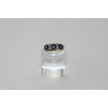 A sapphire and diamond ring claw set with graduated oval stones with pairs of eight cut diamonds