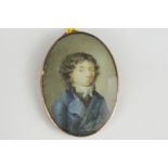 A late 18th century oval miniature portrait of a young man, in a white necktie and blue jacket, on