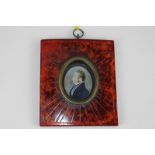 A mid-19th century oval miniature portrait of a gentleman, in blue coat, on ivory, 3.5cm by 3cm