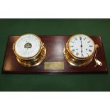 A brass porthole clock and barometer by Hermle, the clock with ships bell chime, mounted on a wooden