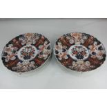 A pair of Japanese Imari porcelain chargers with scalloped border and central circular panel of