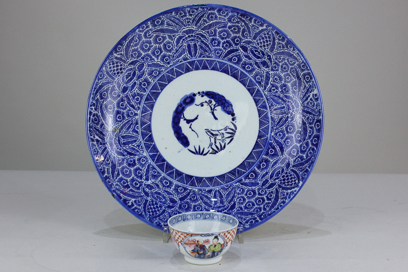 A Chinese porcelain tea bowl depicting seated figures, together with a Chinese blue and white dish