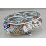 A Chinese porcelain inkwell with all-over polychrome floral design, with Fo dog mask ring lugs, on