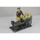A 19th century Continental pottery group, possibly German, of a milkmaid with dog and milk cart,