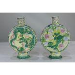 A pair of Chinese porcelain moon flasks depicting a green dragon chasing a flaming pearl on yellow