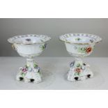 A pair of Dresden style porcelain pedestal bowls, circular shape with pierced borders, on scroll and