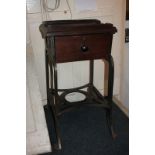 A printer's table with rectangular top with raised border, single drawer, on cast iron legs and