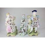 A pair of Continental porcelain figures of a man and a woman in Regency dress standing by bud