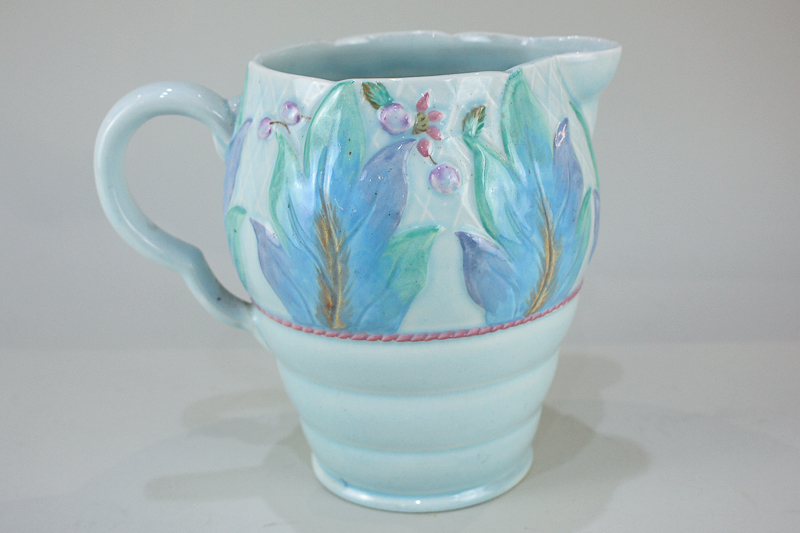 A Clarice Cliff Newport pottery jug with floral frond design on pale blue ground, 19cm high