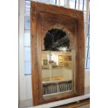 An Indian carved wood rectangular wall mirror, possibly converted from a window, with arch shaped