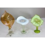 Three similar lily shaped coloured glass vases with petal shaped rims, in different colourways (a/