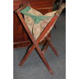 A folding mahogany sewing stand with cotton bag, on trestle supports, 82cm by 32cm
