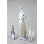 A Nao porcelain figure of a woman with basket of apples, 35cm high, a Lladro figure of a kneeling