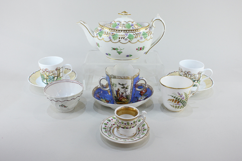 A Dresden porcelain twin-handled cup and saucer decorated with panels of figures and flowers (a/f)