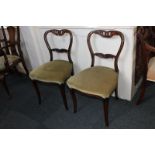 A pair of Victorian dining chairs with carved floral entwined bar backs, green upholstered seats, on