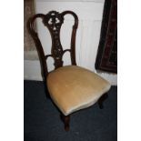 A Victorian mahogany nursing chair, with foliate pierced back and upholstered seat, on cabriole
