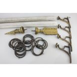 A wooden curtain pole, 142cm long, with gilt brass arrow stoppers and metal curtain rings,