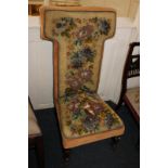 A prie dieu chair with bead and tapestry upholstery (seat damaged), on turned front legs and castors